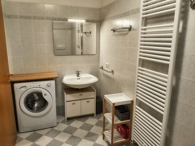 Bagno con lavabo, lavatrice e scaldasalviette