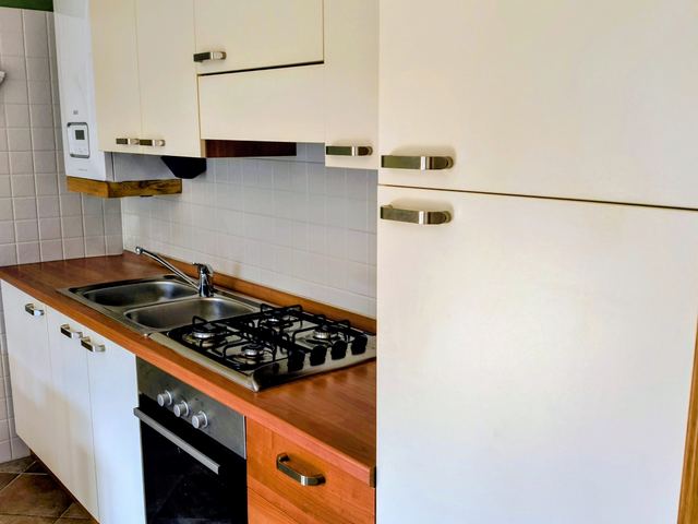 Cucina con frigorifero, forno e piano cottura